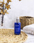 lavado de cara organico con baja sensibilidad botella azul de gel limpiador ium en baño luminoso con accesorios beige