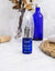 serum facial bio botella azul de serum ium en baño luminoso con accesorios beige